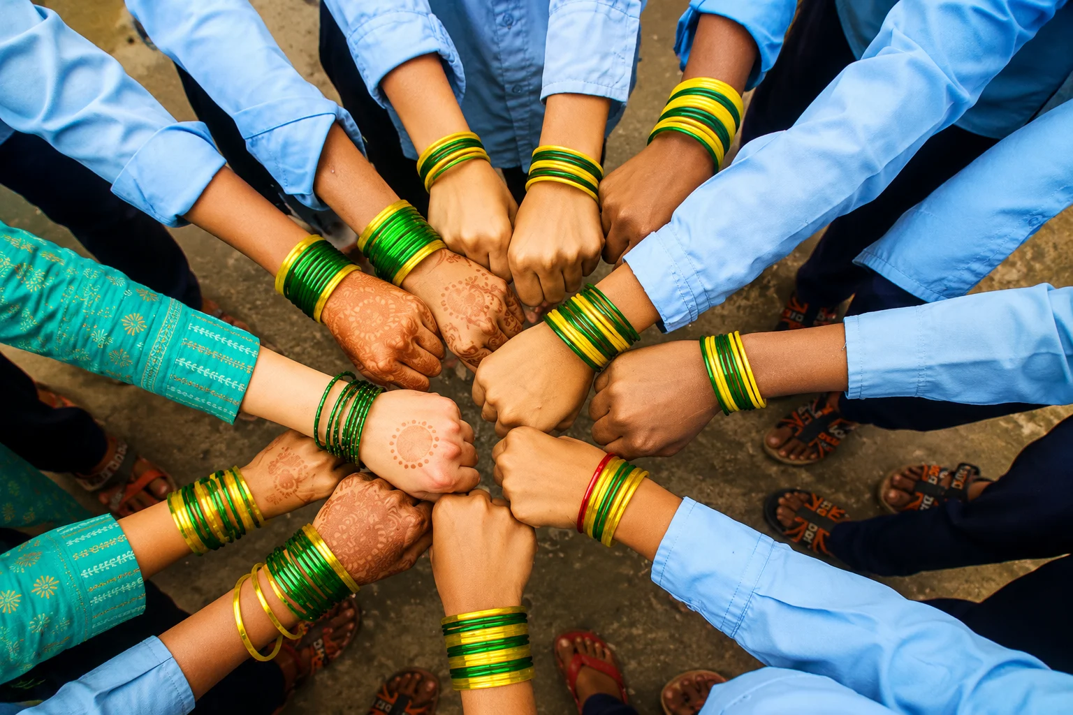 Girls joining hands in a circle wearing green bangles