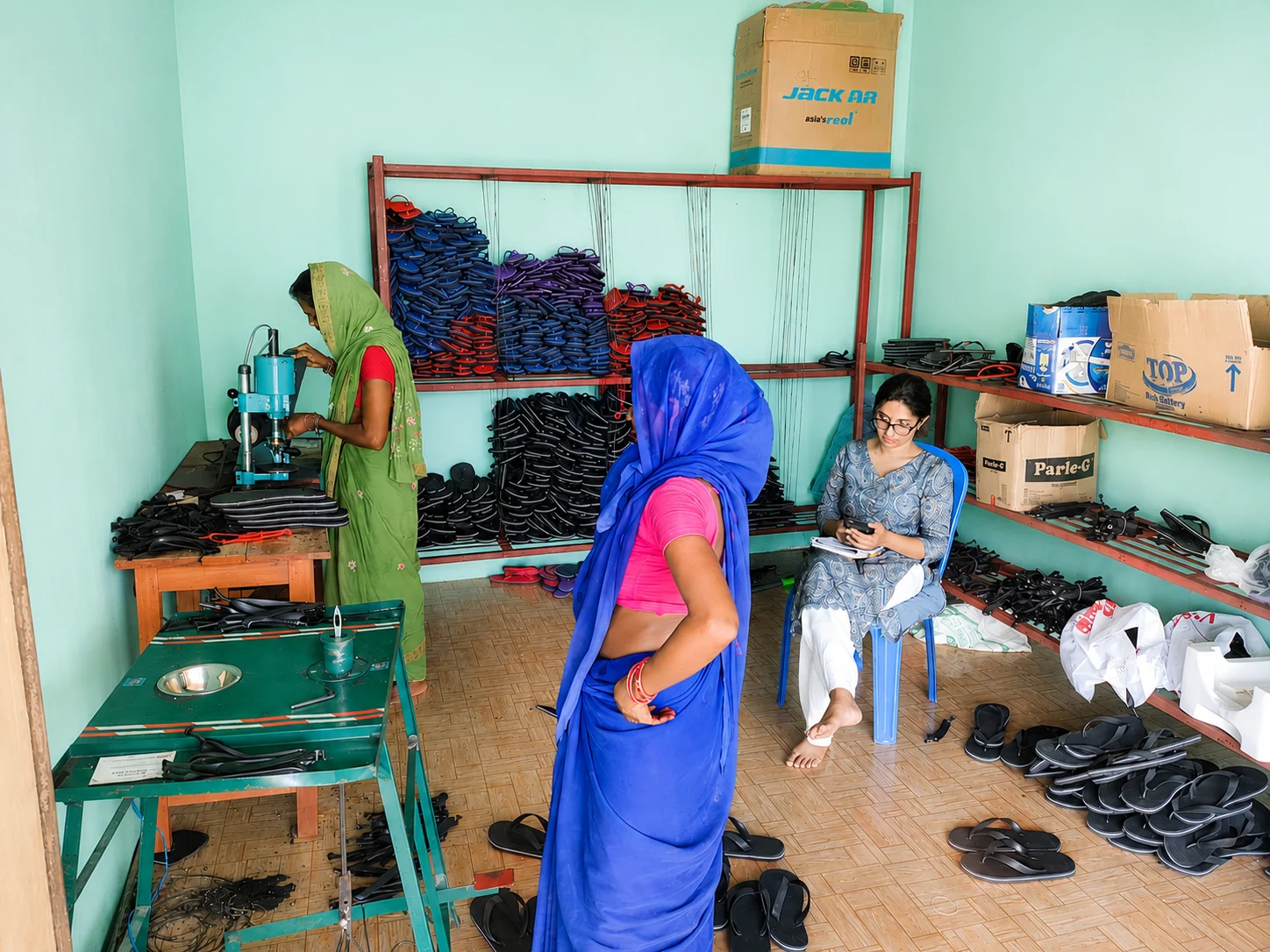 Woman talking with another woman in a small shoe-making workshop