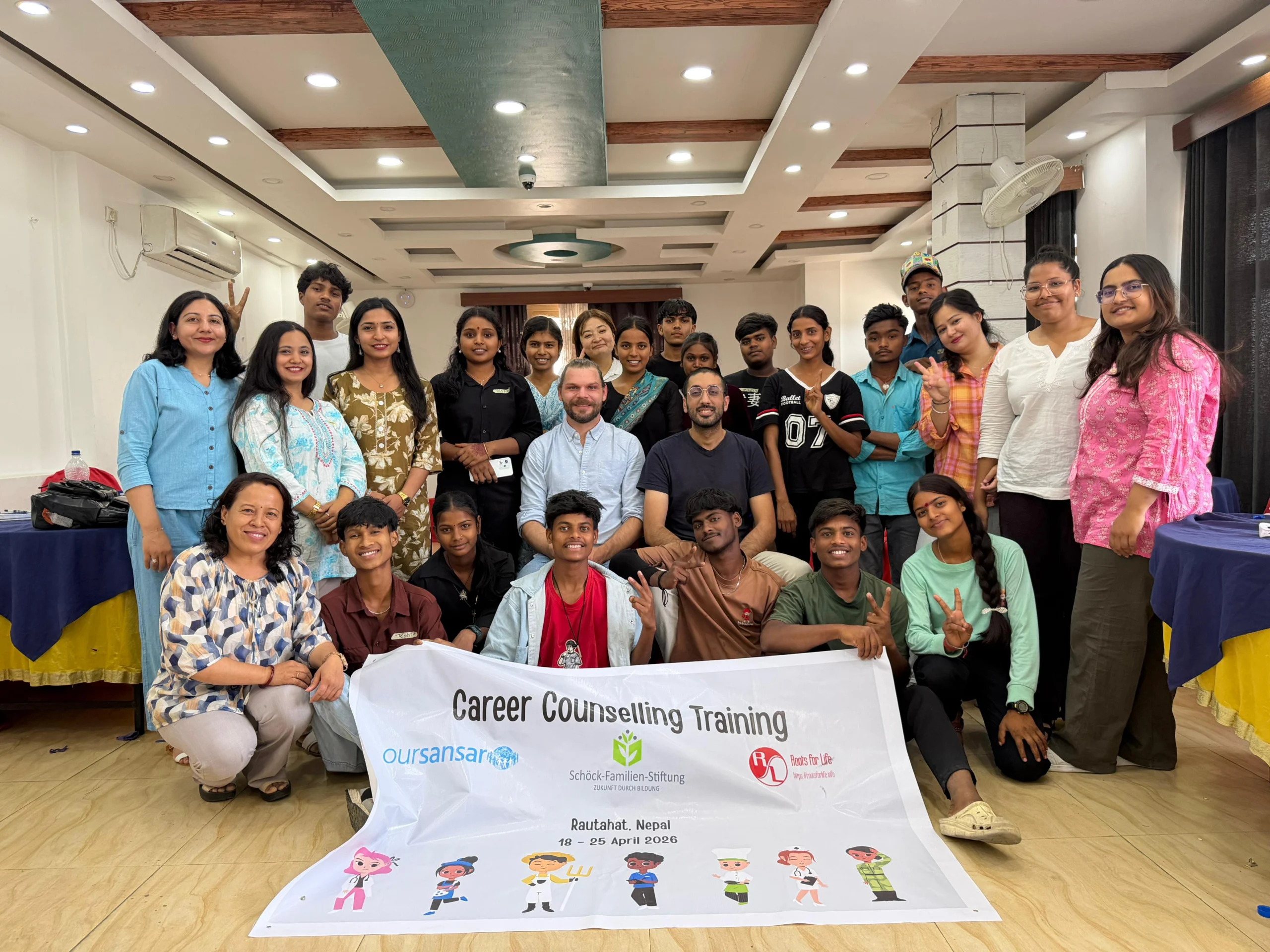 Group photo of staff and community members holding a counselling training banner