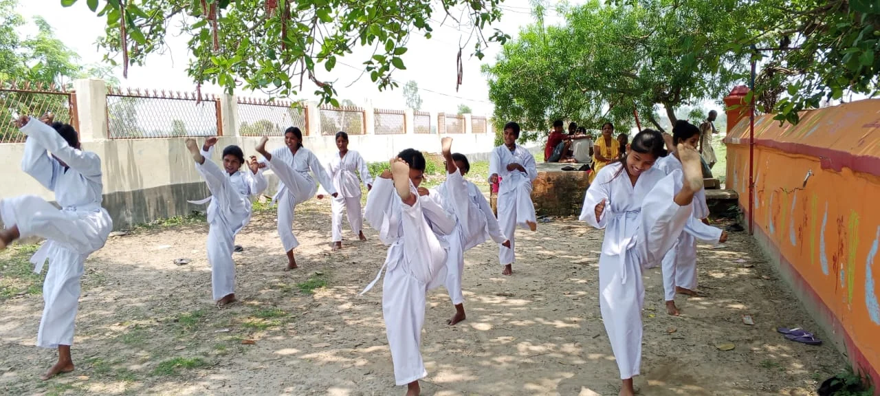 Children practising martial arts in white uniforms outdoors