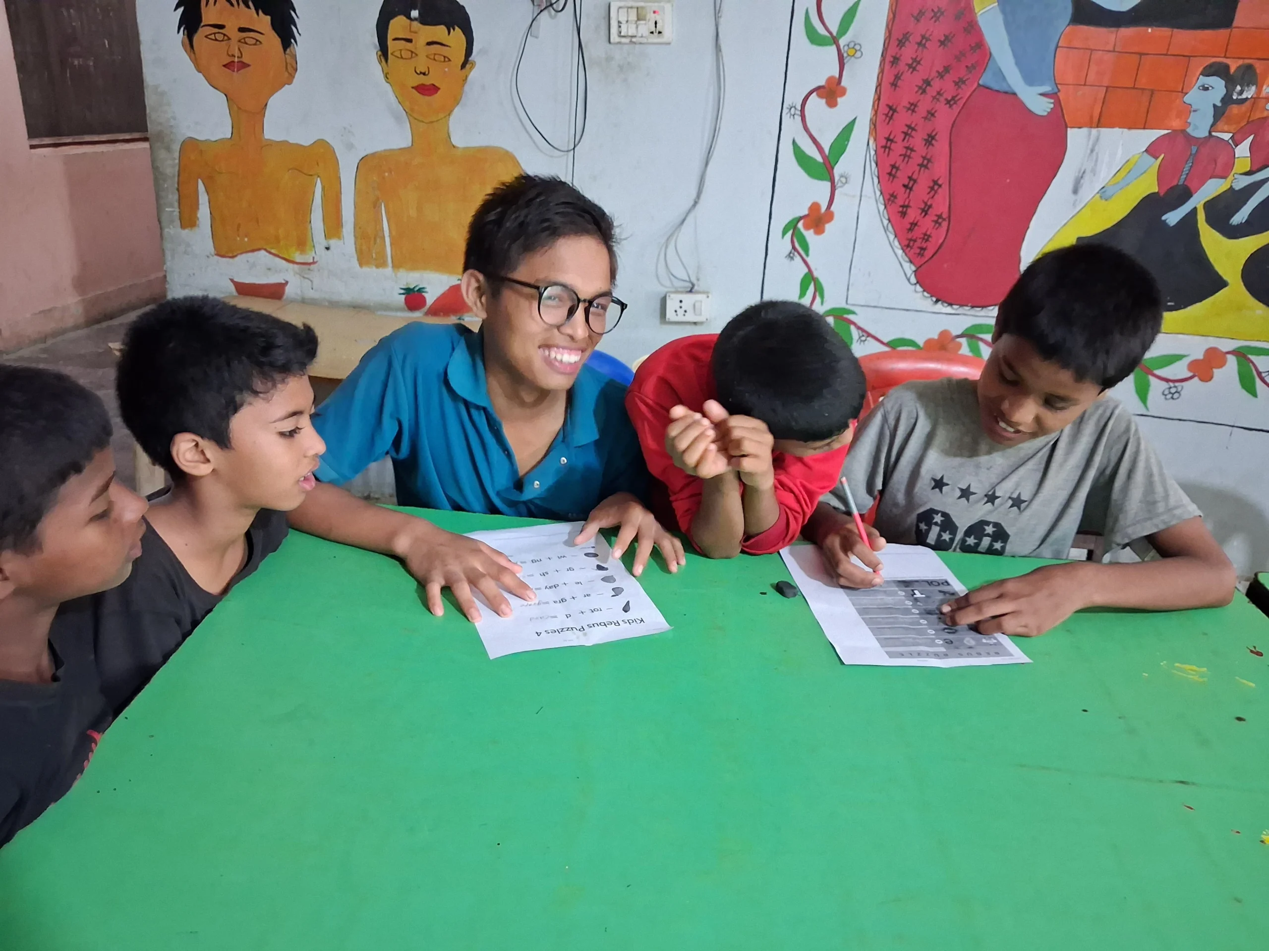 Smiling children doing activities at a green table