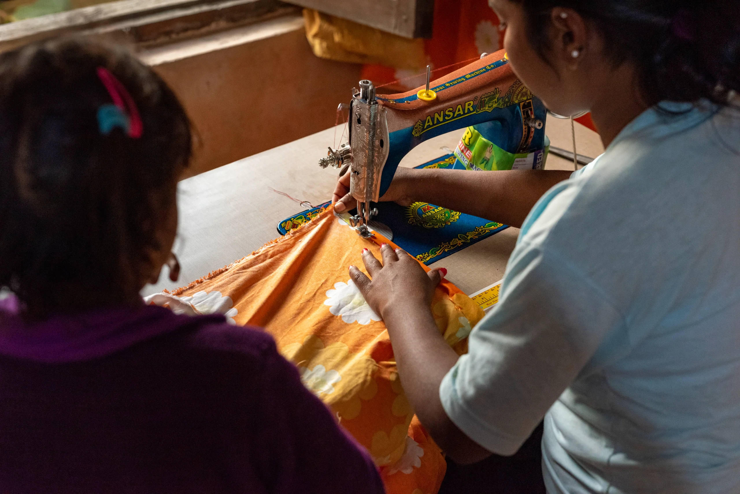 Girl learning to sew at a sewing machine