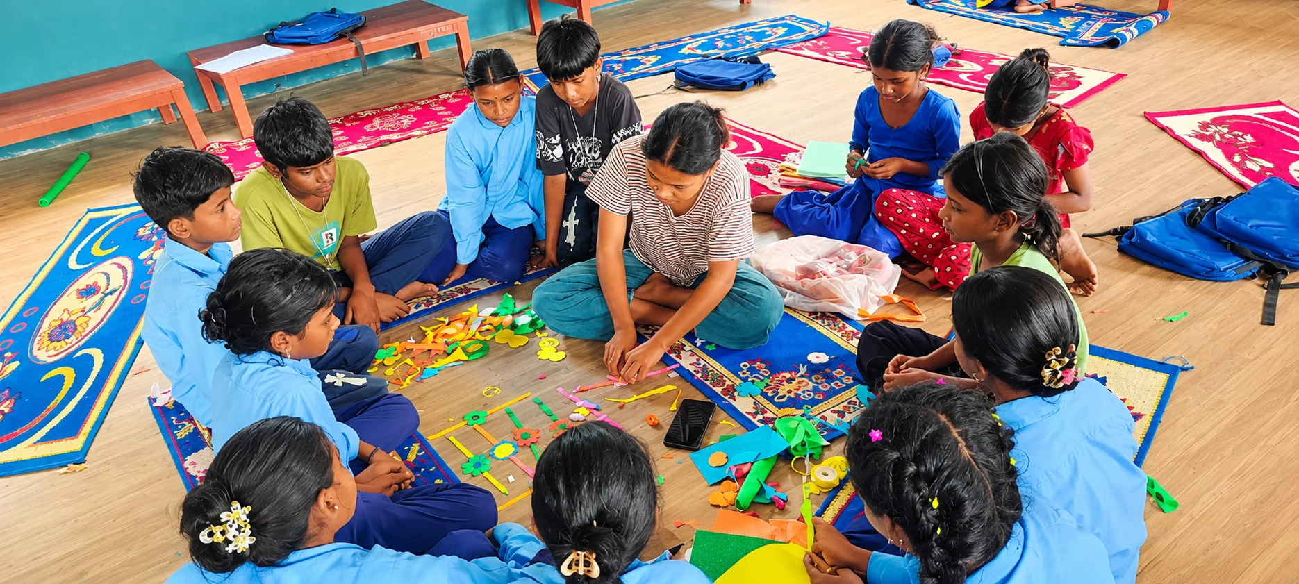 Children sitting in a circle on colourful mats playing a game