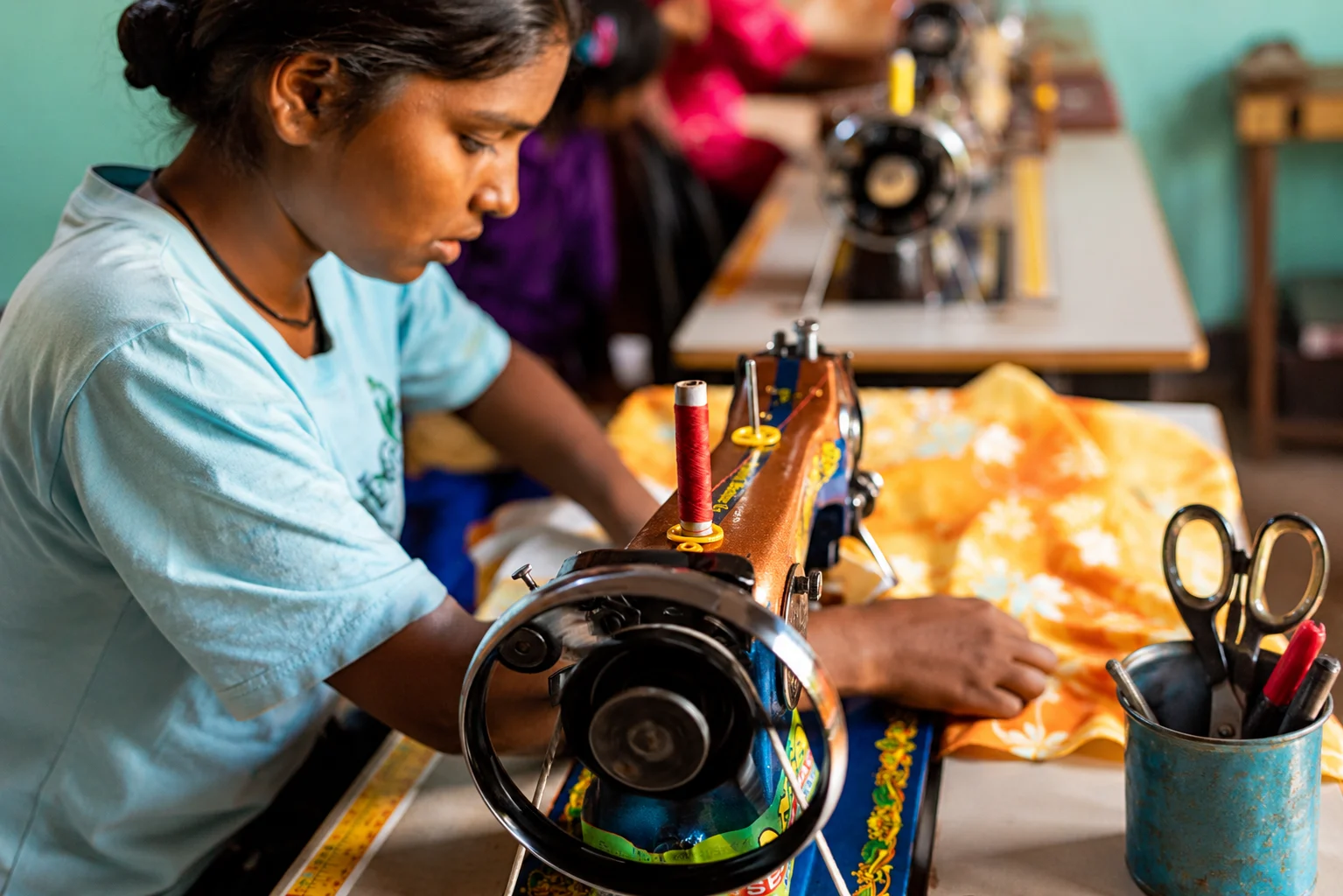 Girl using a sewing machine in a workshop