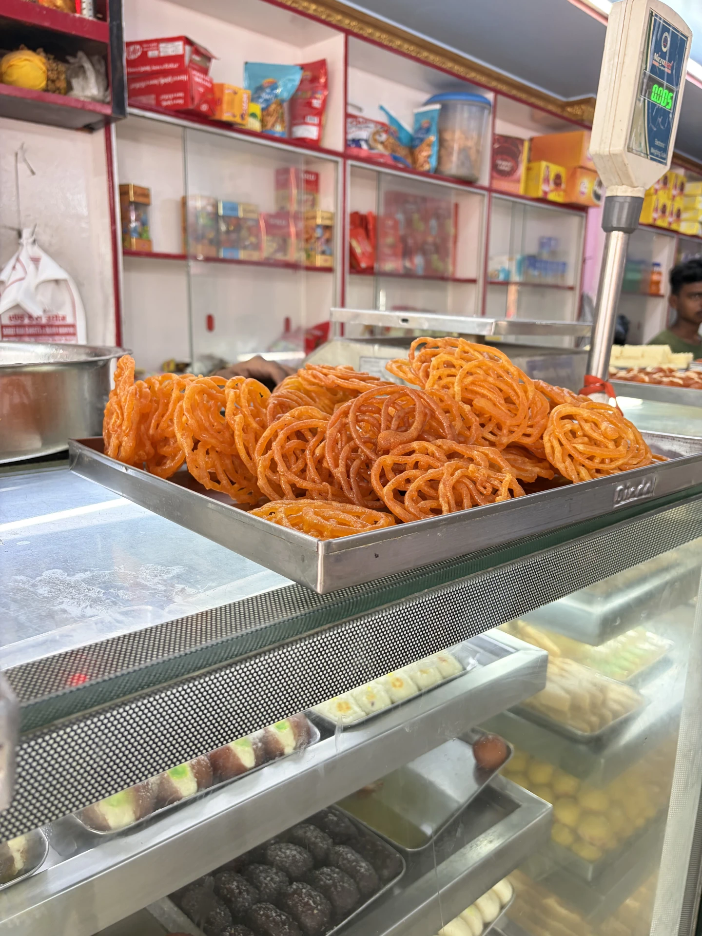 Orange jalebi sweets on display in a shop counter