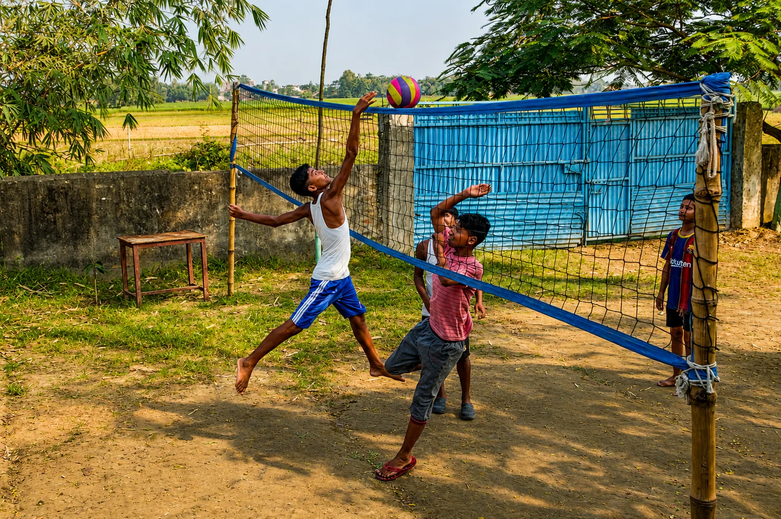 Young people playing volleyball outdoors