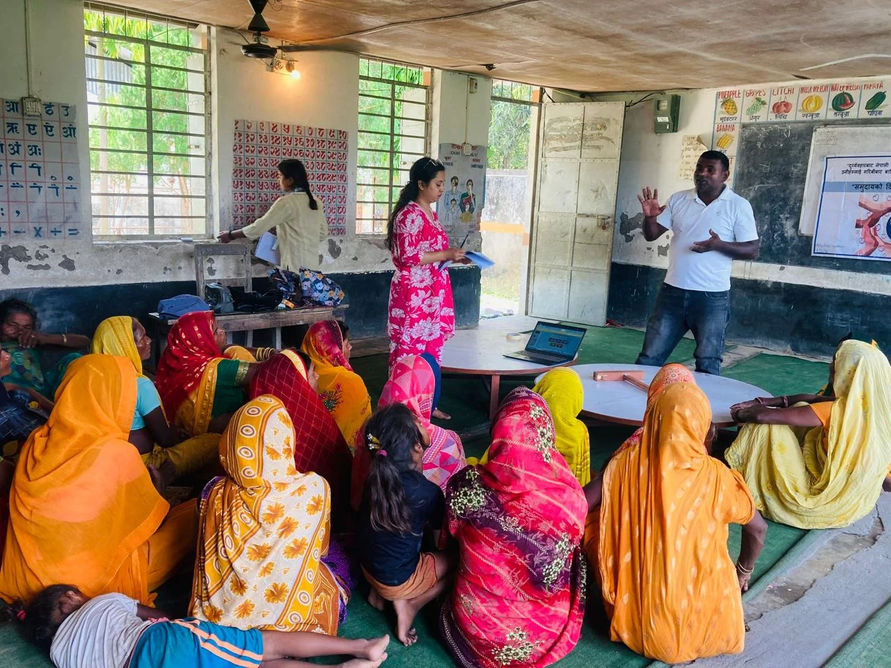 Women in bright saris attending a class led by teachers
