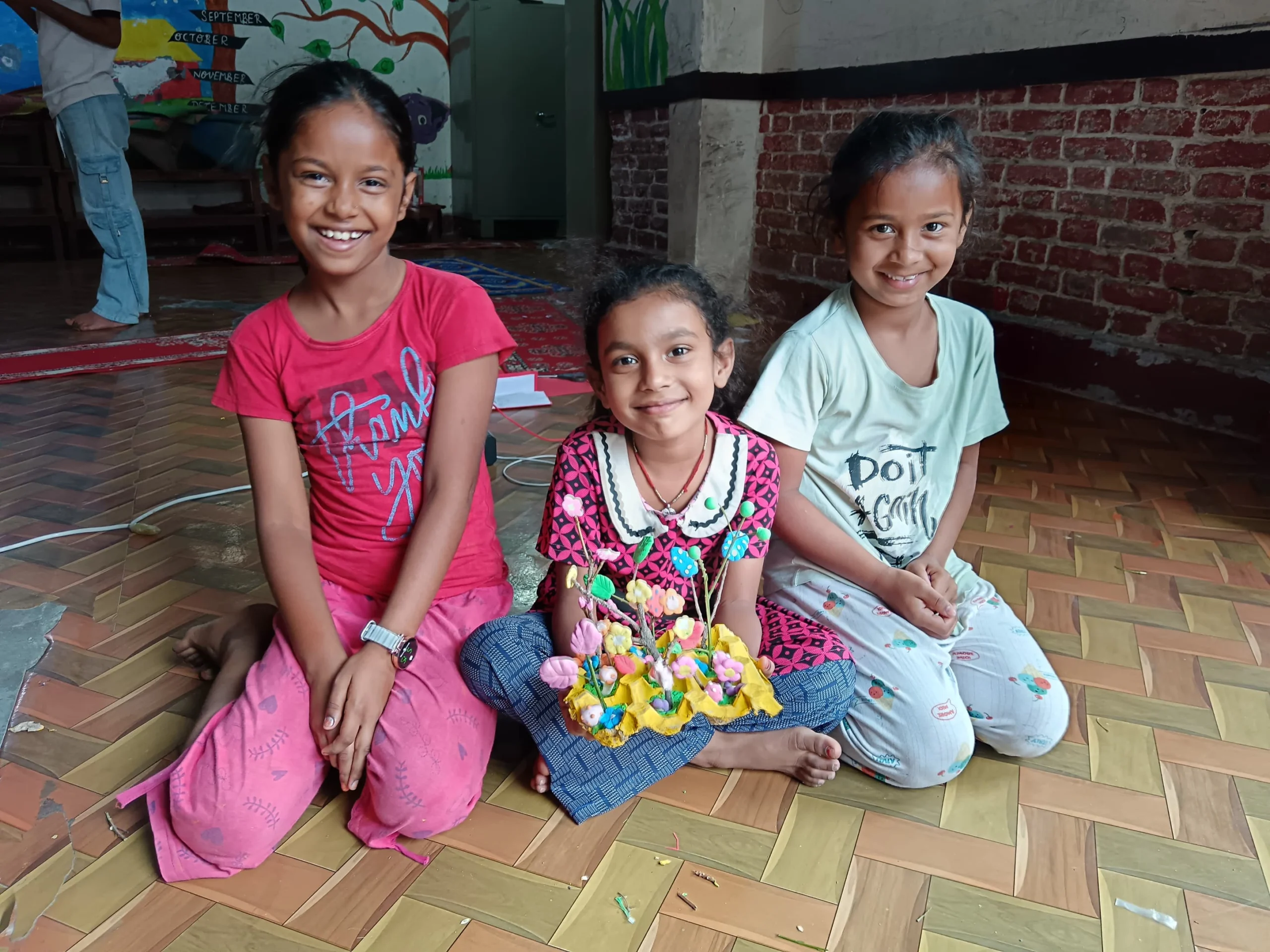 When children are found living on the streets Three smiling girls sitting together on the floor
