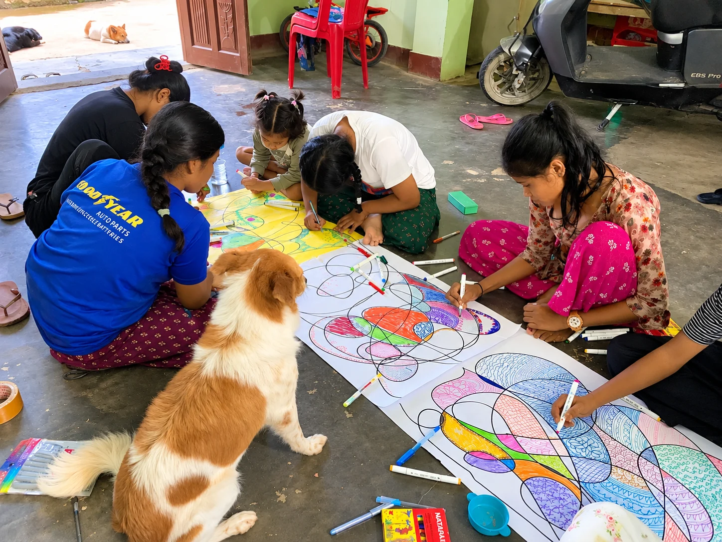 Creating Lasting Change Women and a small dog gathered around a large colourful artwork on the floor